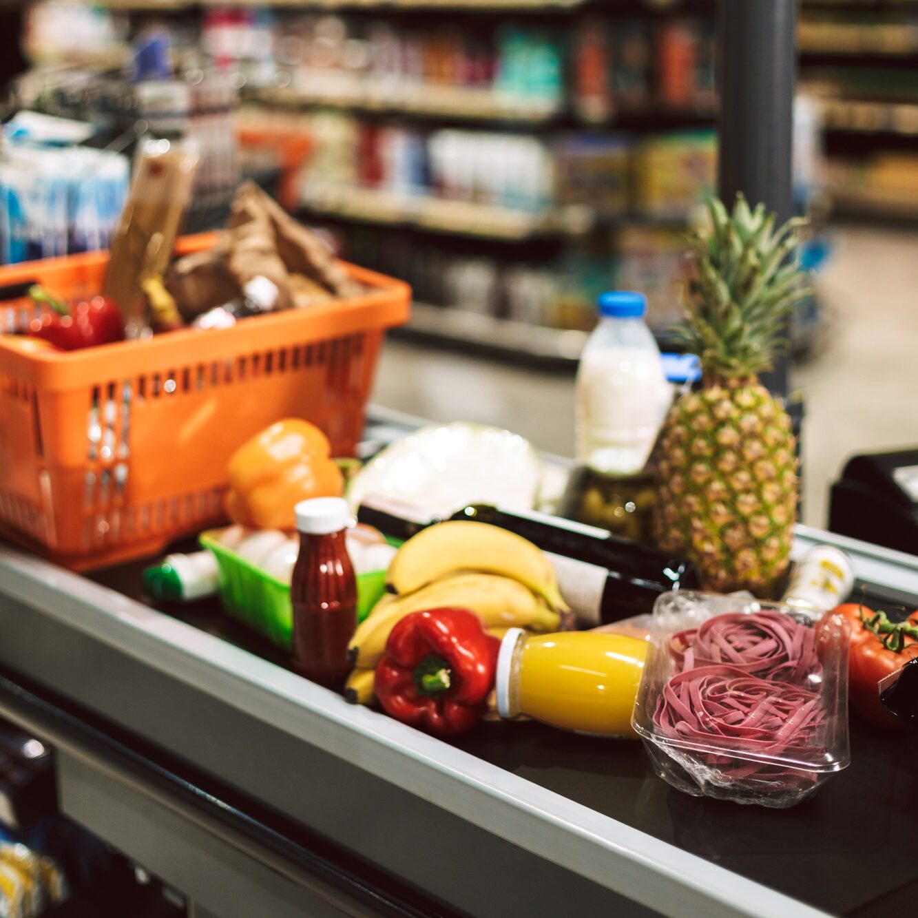 Close up shopping basket and products on cashier desk in superma